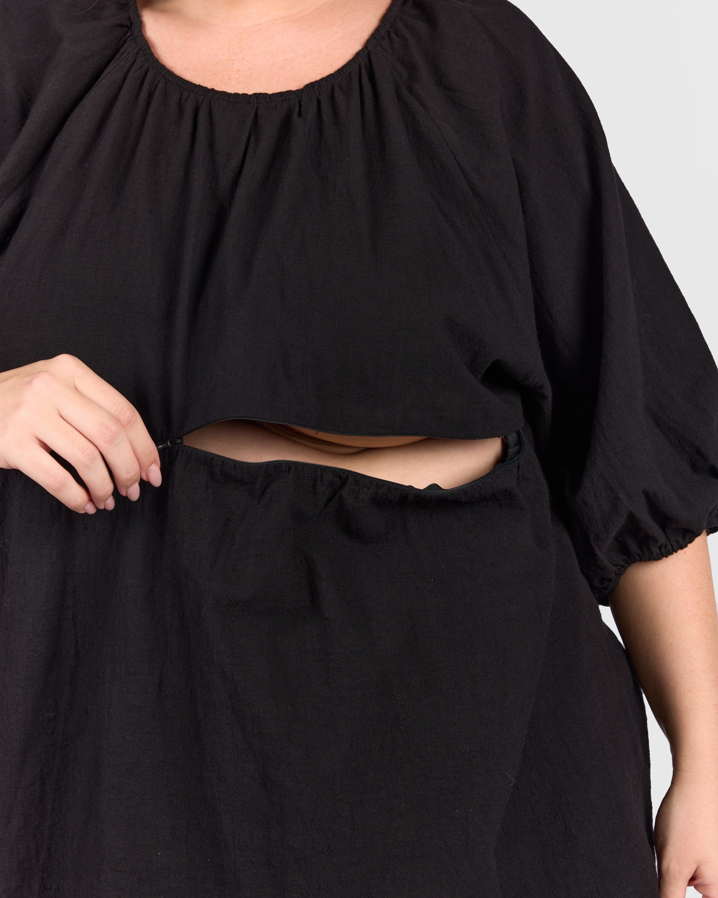 Close up of black peplum top with hidden breastfeeding zip.