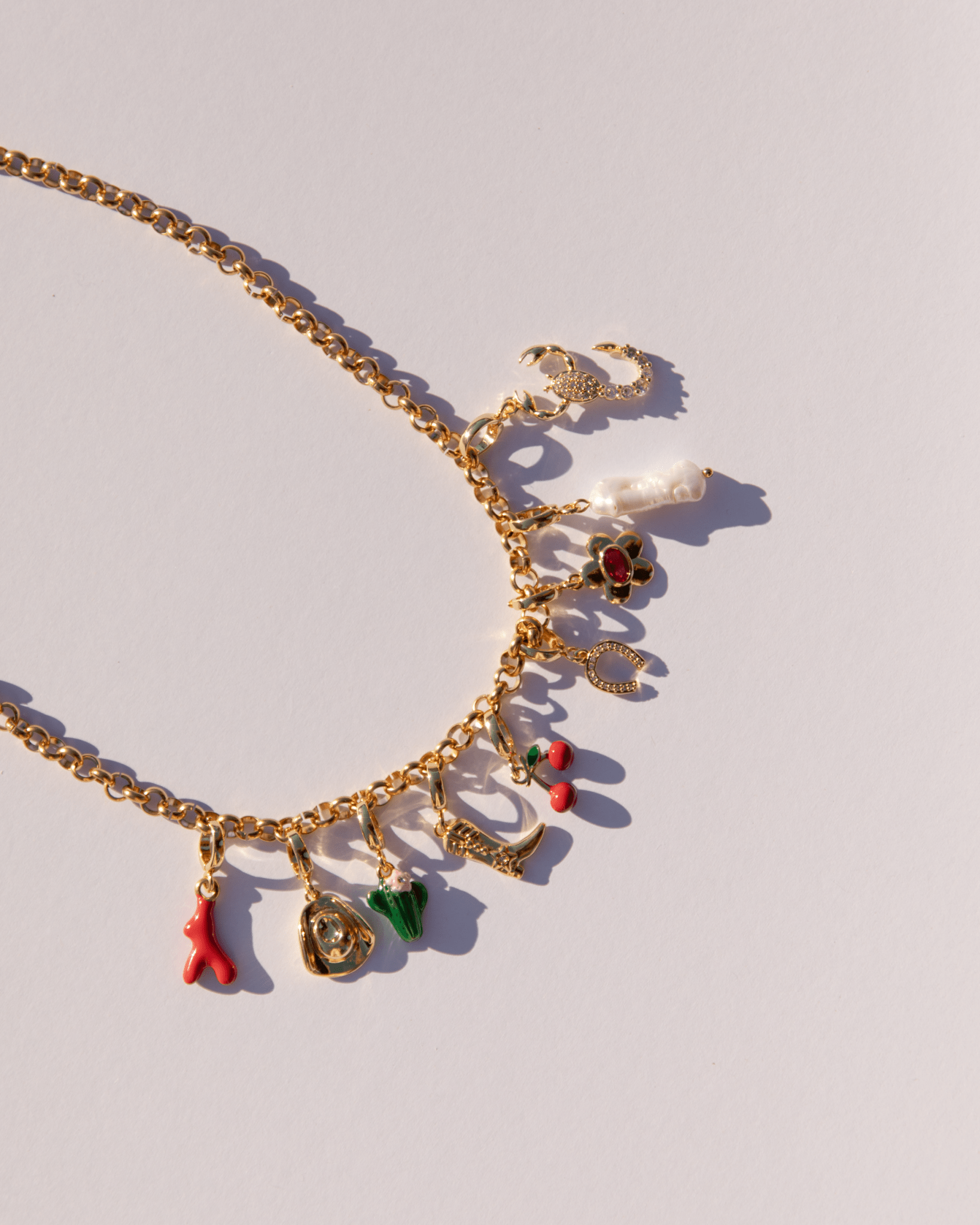 Chunky gold chain necklace with an assortment of charms attached.