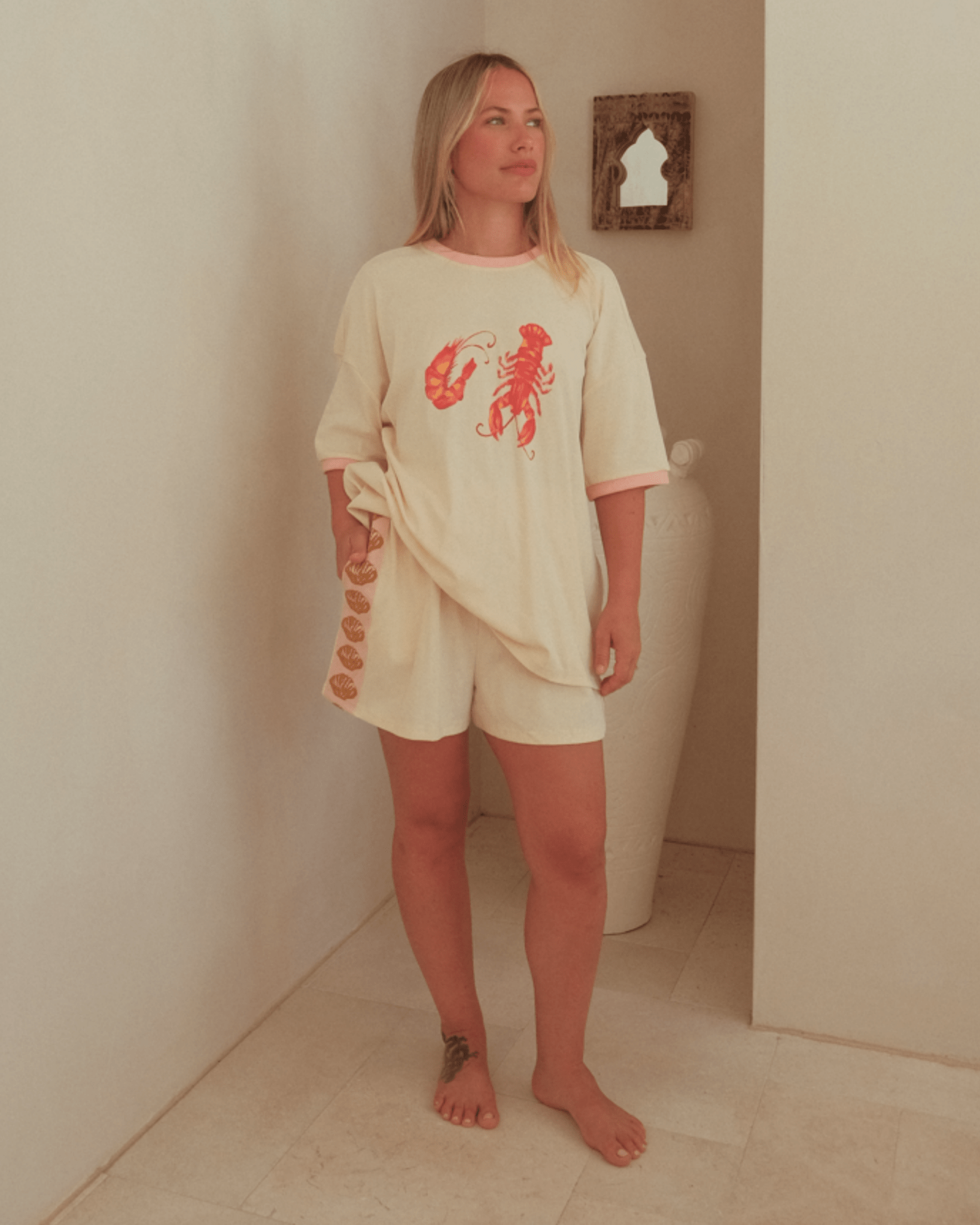 Woman wearing cream coloured matching oversized t-shirt and relaxed shorts.