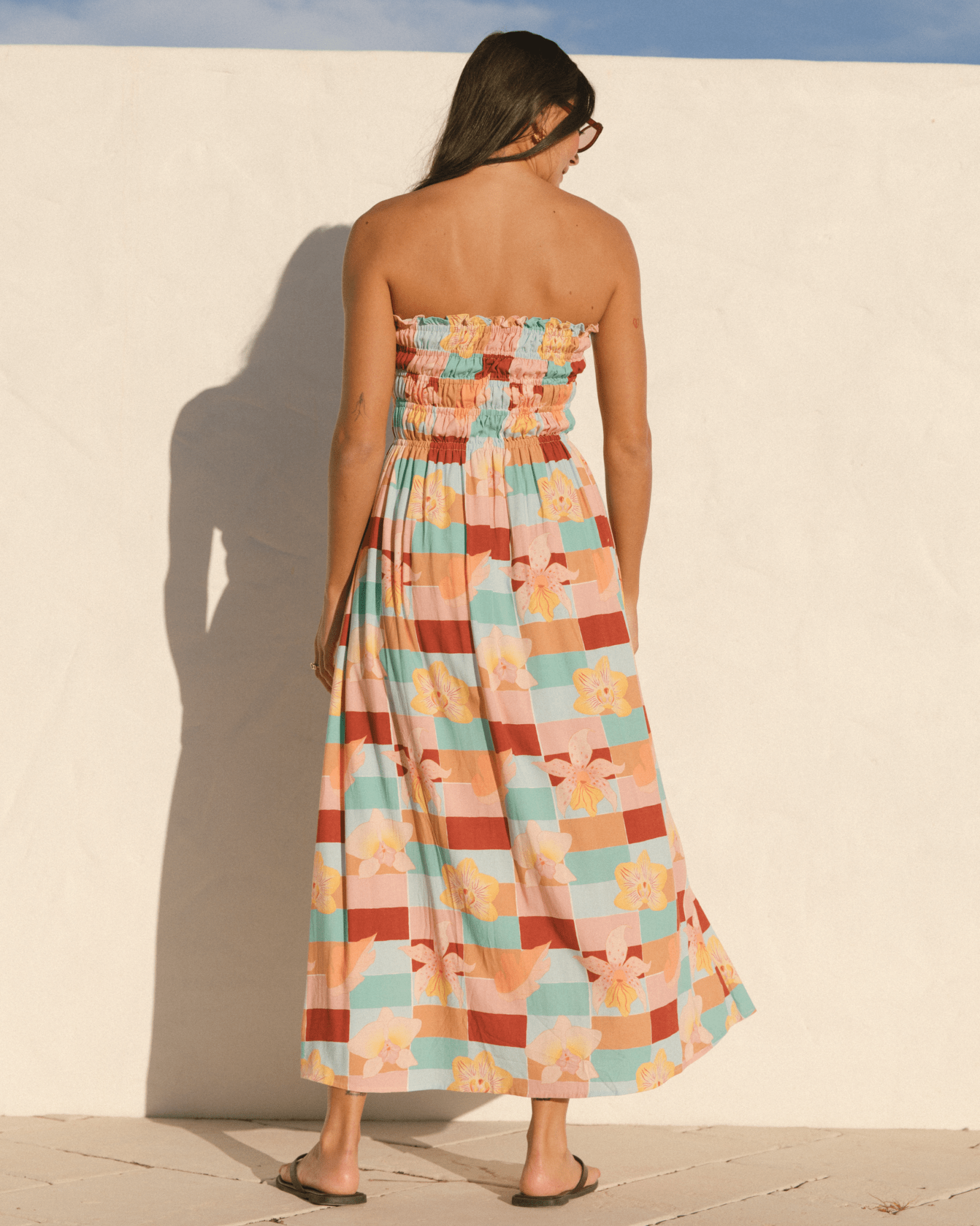 Woman wearing a colourful spring strapless dress.