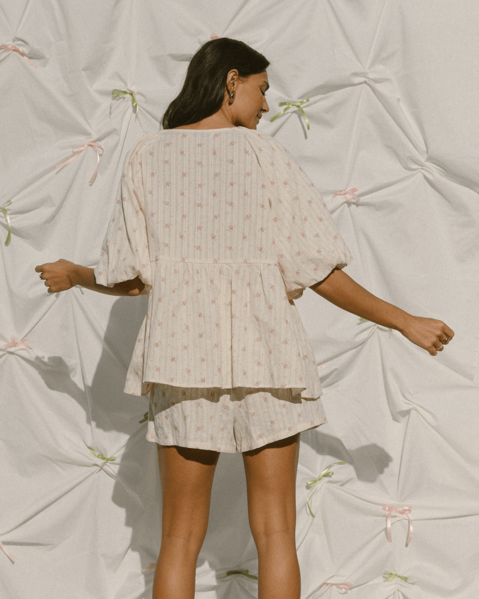 Woman wearing cream coloured with pink flowers delicate clothing set