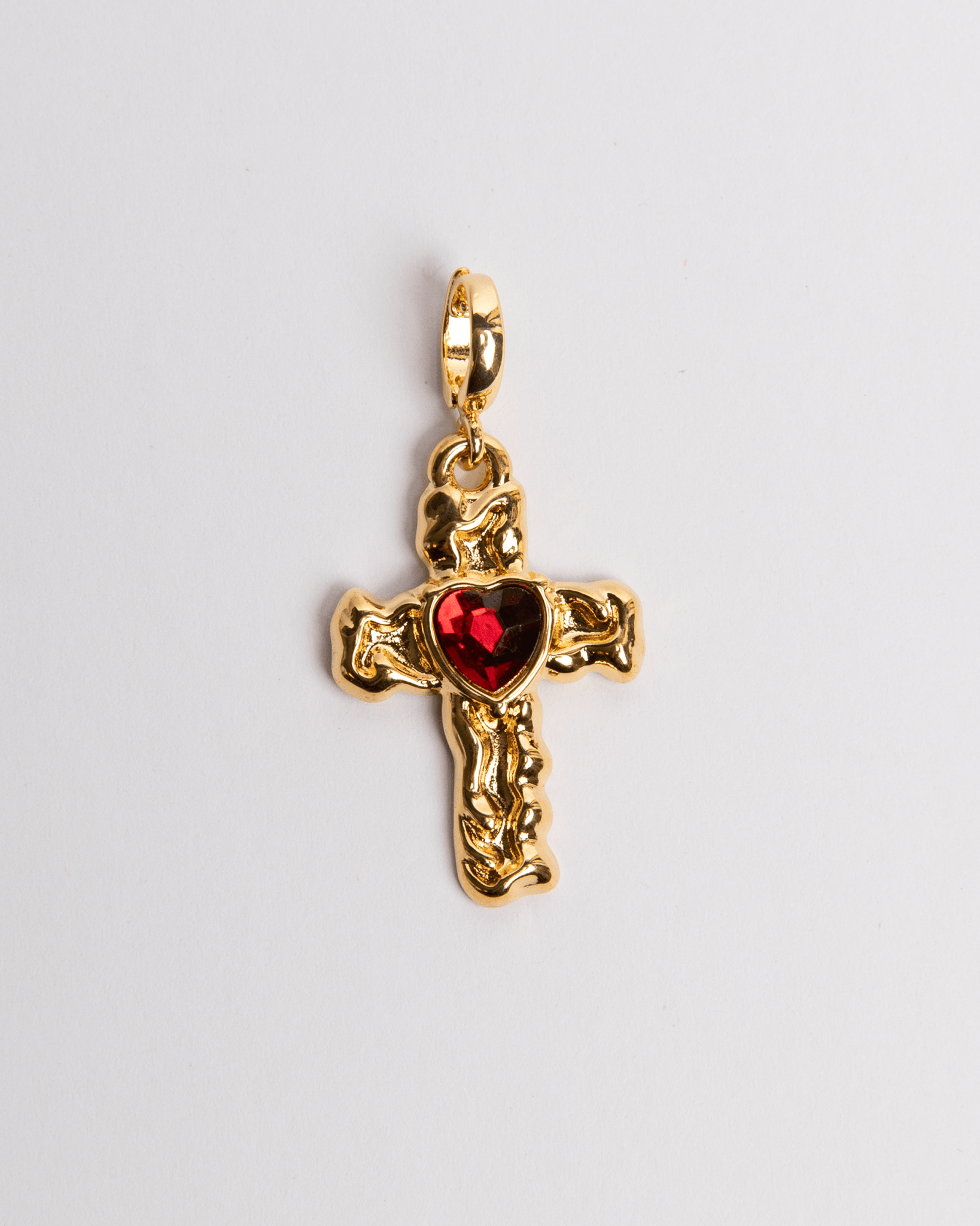 A gold-plated stainless steel cross charm with a red heart in the center.