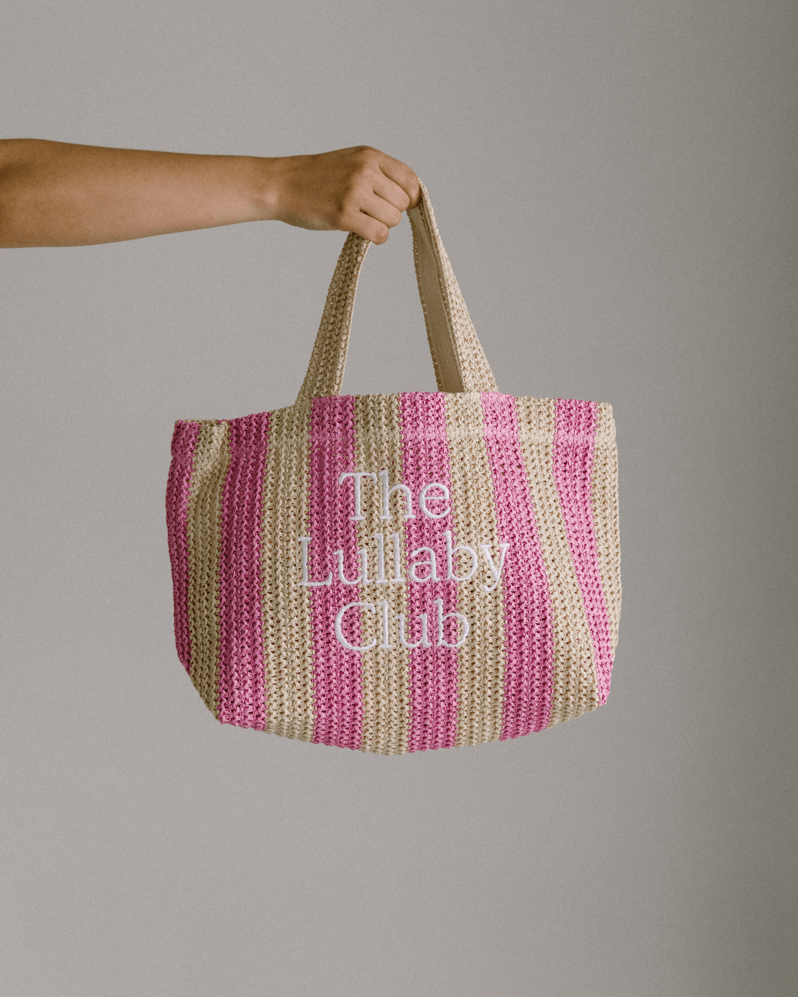Raffia tote in pink & natural stripes with 'The Lullaby Club' embroidered on the front.