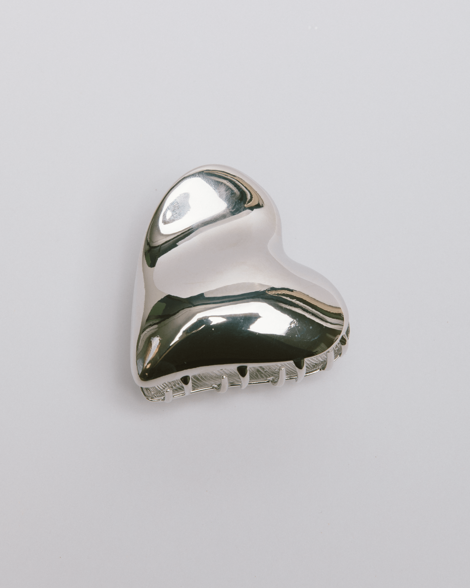 Silver wavy heart shaped hair clip accessory.