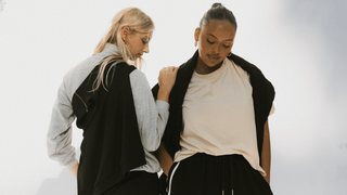 Two women standing next to each other posing, wearing tracksuit sets