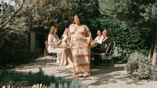 Four women wearing floral and floaty outfits in a garden