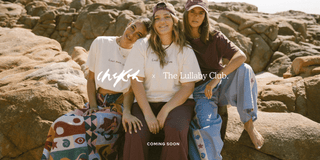 Three women wearing linen printed sets, relaxed sitting on stairs outside in a fashionable manner