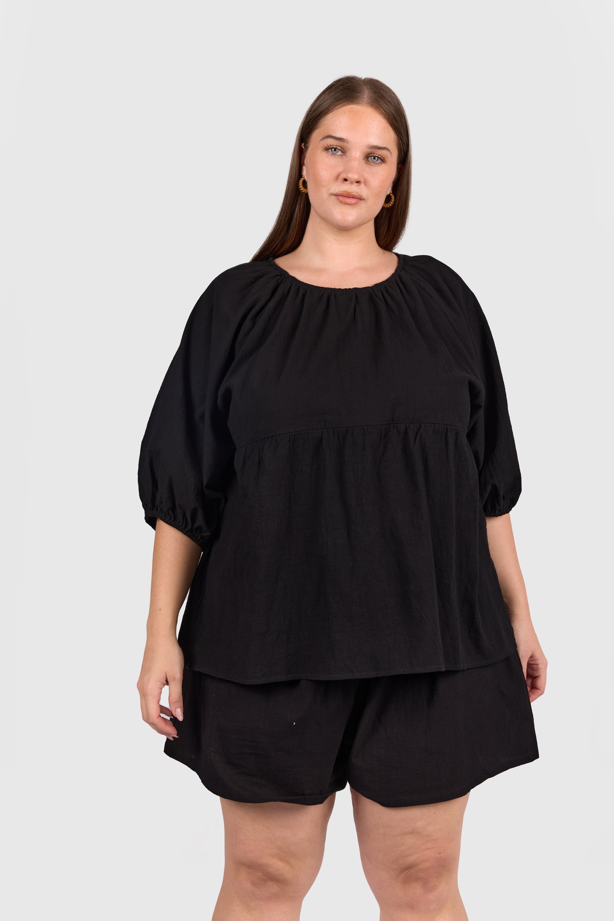 Woman wearing matching black cotton set, that is breastfeeding and bump friendly. 