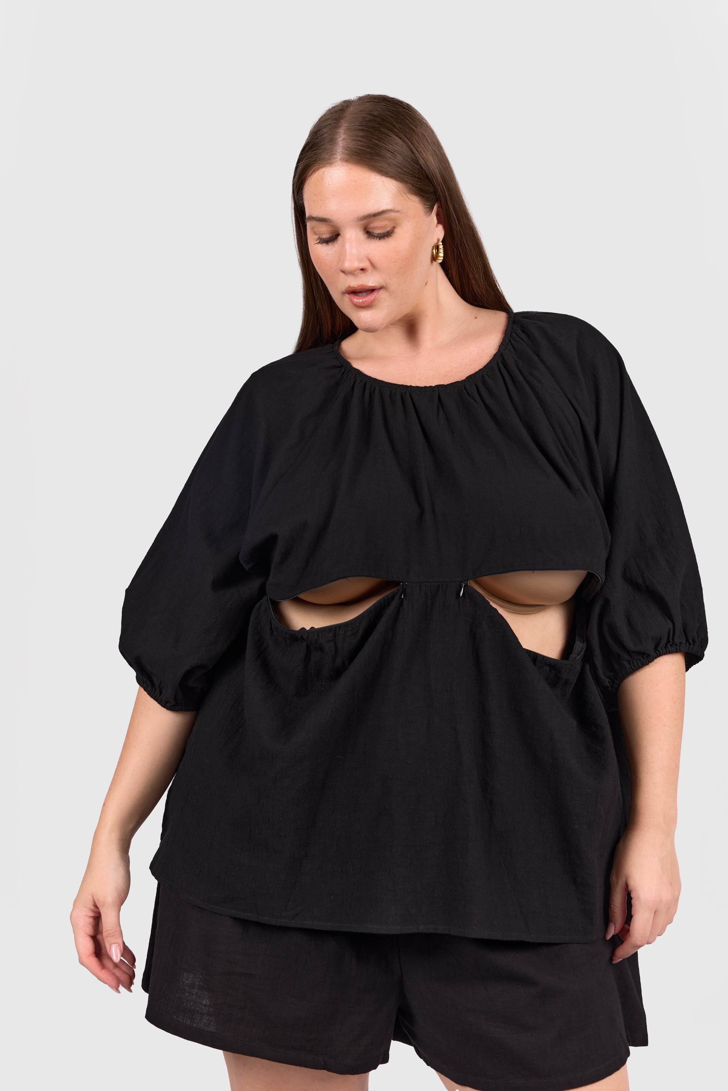 Woman wearing black reversible top with breastfeeding access. 