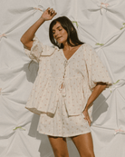 Woman wearing oversized, flowy top and shorts set. 