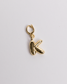 A gold-plated stainless steel charm in the shape of the letter K with a secure clasp designed for attaching to necklaces or bracelets.