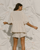 Woman wearing cream coloured with pink flowers delicate clothing set