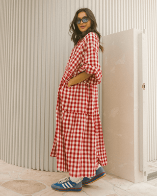 Woman in flowy postpartum-friendly maxi dress in red gingham