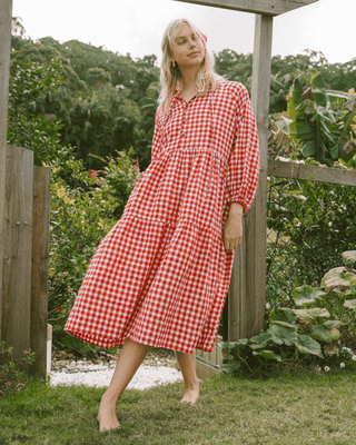 Woman in flowy postpartum-friendly maxi dress in red gingham