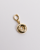 A gold-colored charm in the shape of the letter O with a secure clasp designed for attaching to necklaces or bracelets.