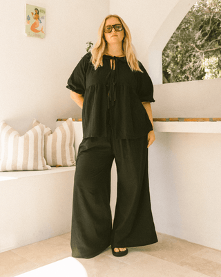 Pregnant woman wearing black maternity lounge pants - Posey Pants by The Lullaby Club