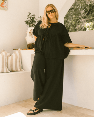 Pregnant woman wearing black maternity lounge pants - Posey Pants by The Lullaby Club