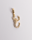 A gold-colored scorpion-shaped charm with a secure clasp for easy attachment, displayed against a white background.
