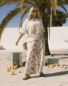 Woman in casual stylish outift featuring wide, relaxed, tucked in tshirt with high waisted full length relaxed pant.