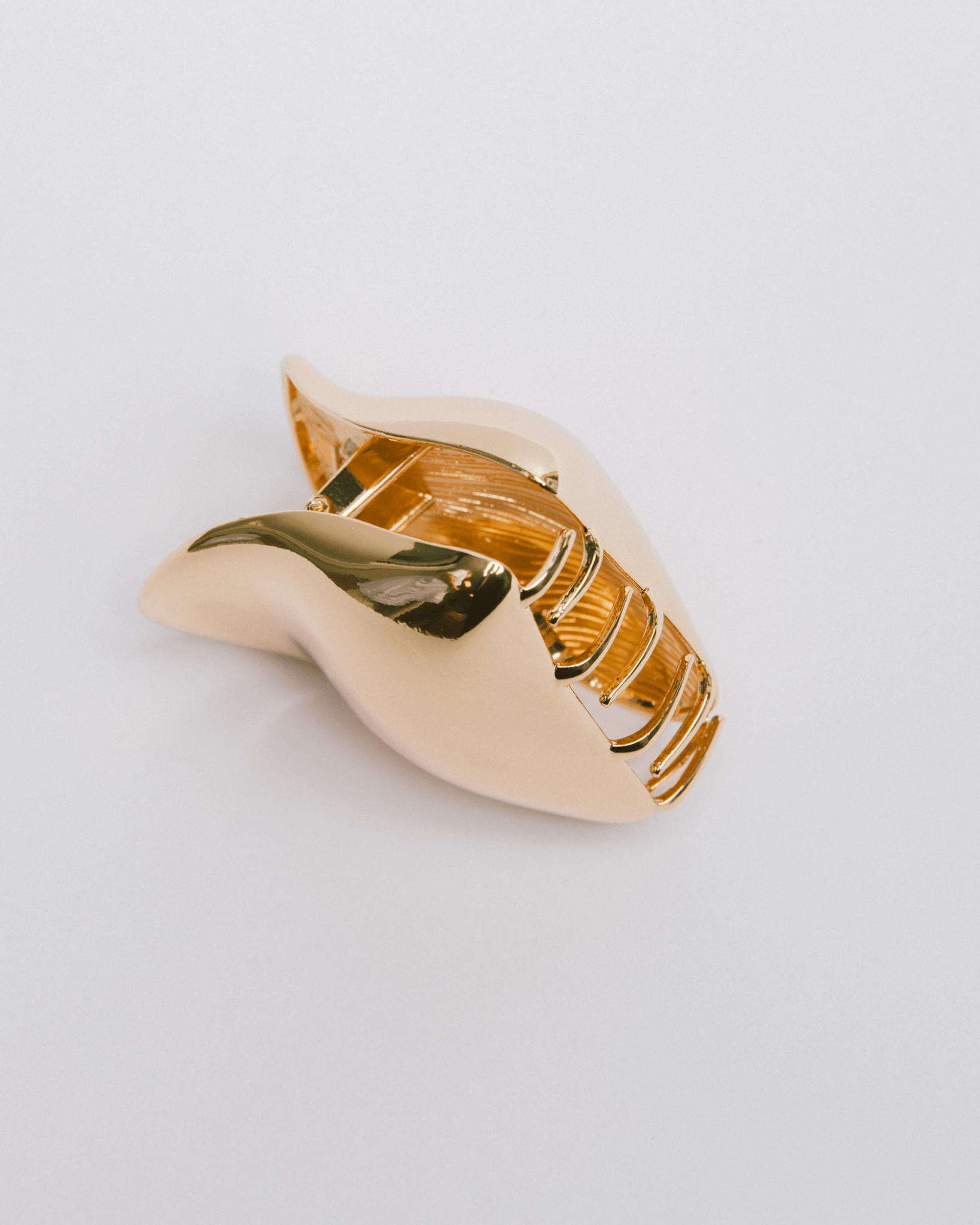 Gold wavy hair claw clip on a light gray background