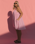 Woman wearing strapless summer mini dress in a bubblegum pink colour. 